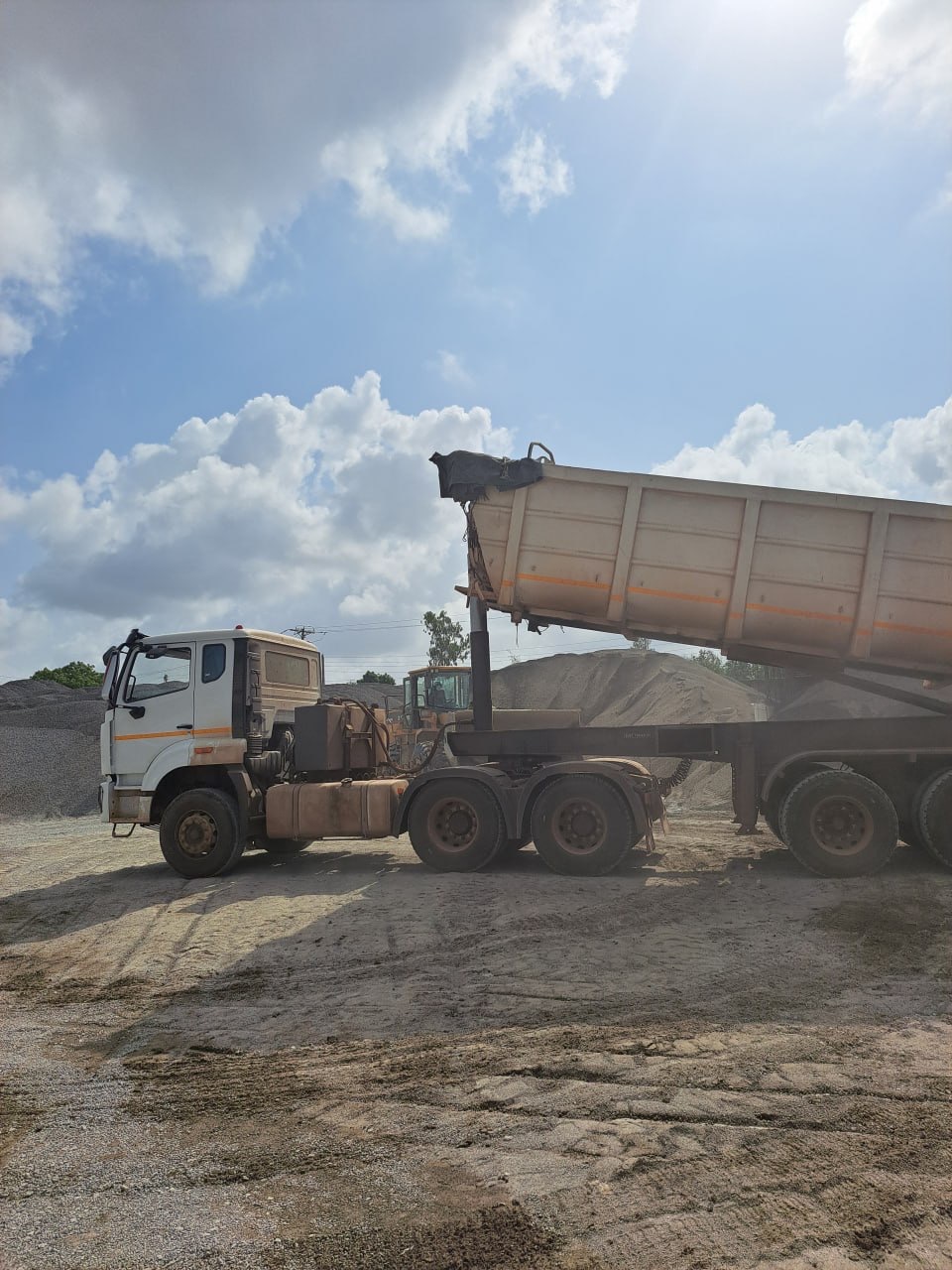 Tipper trailer discharging quarry dust at the loading bay